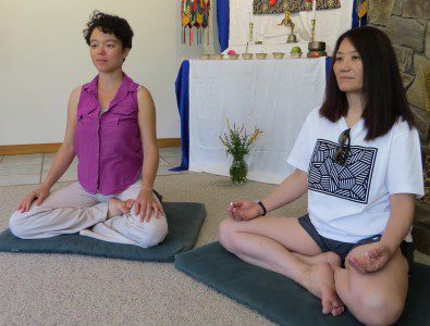 two women meditating in a shrine room