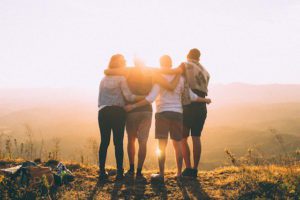 4 people hugging at sunrise